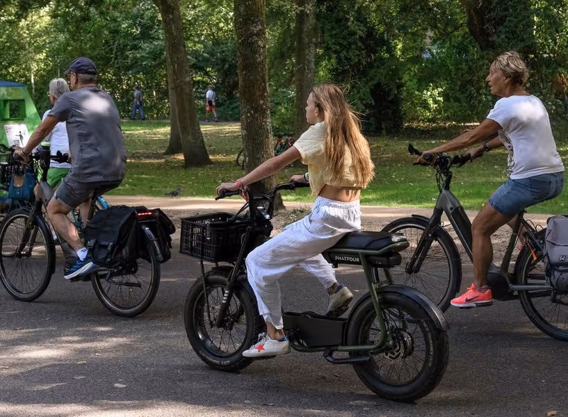 Een groepje jongeren fiets op fatbikes door een park